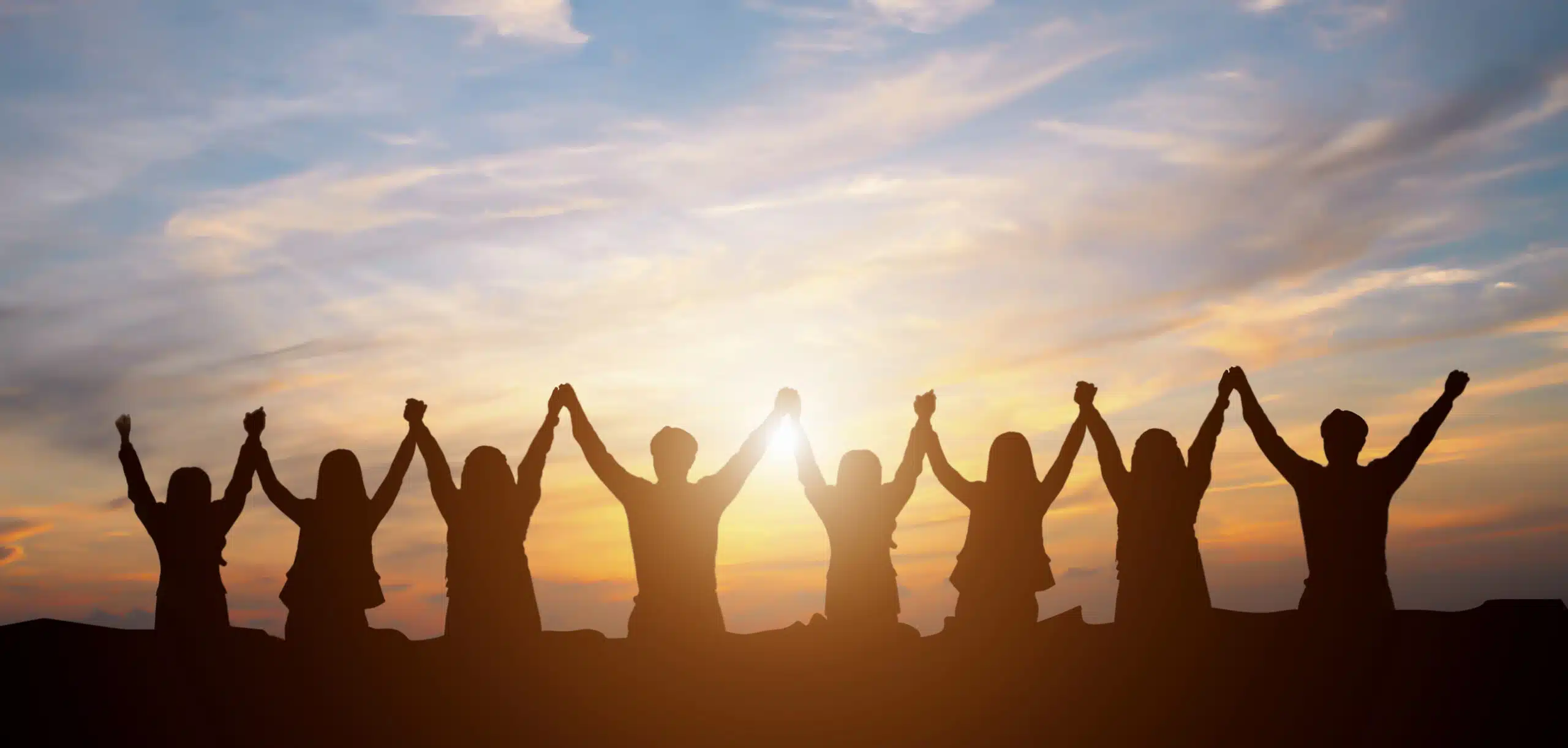 team of people with the sun setting in the background