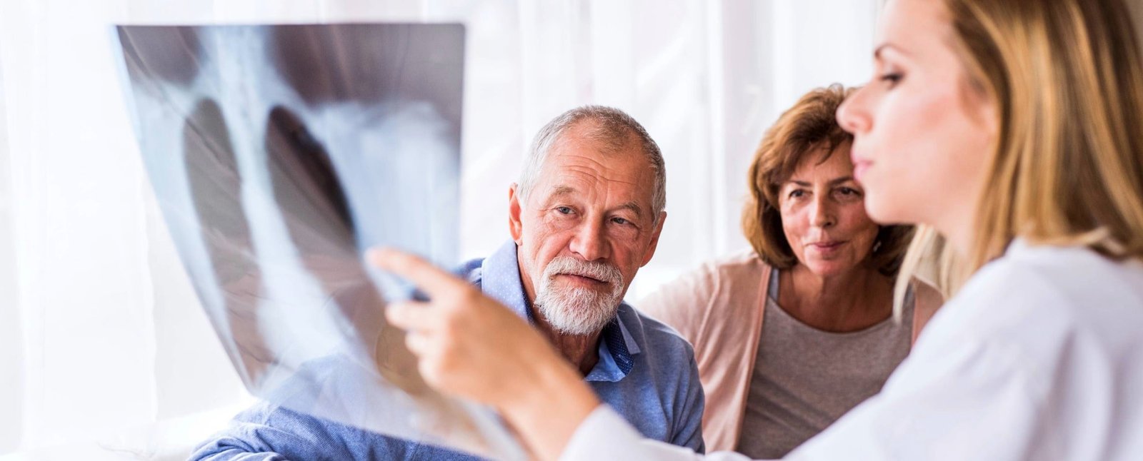 couple looking at x-ray with technician